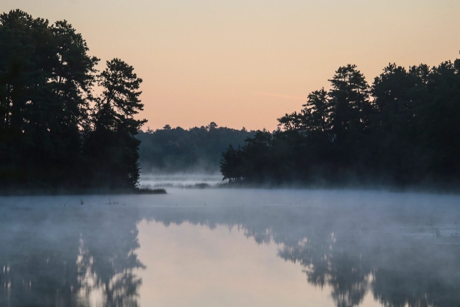 Mist over a quiet northern Ontario lake at sunrise